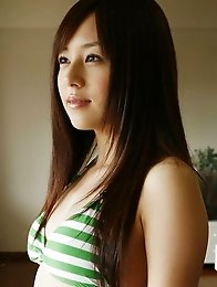 Alluring asian babe taunts in her green and white bikini